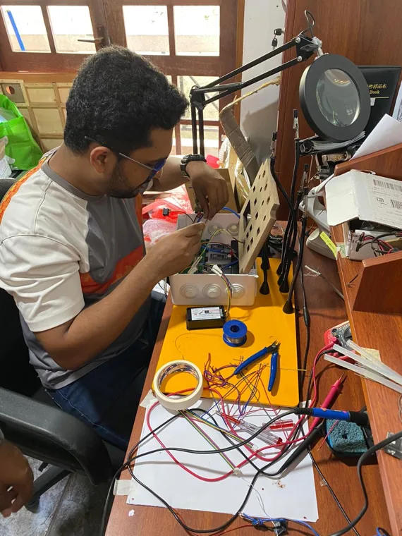 An engineer working on a small assembly at an electronics bench.