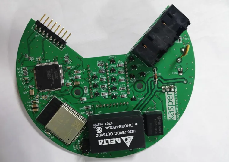Circular green PCB with electronic modules and connectors.