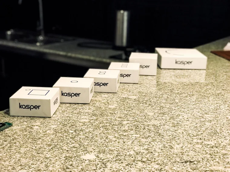 Several small white Kasper-branded enclosures arranged on a counter.