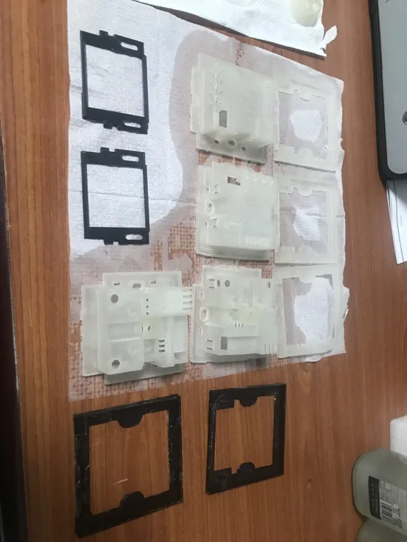 Translucent enclosure parts and dark frames arranged on a work surface.